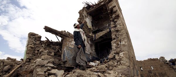 A man points up at a house that was damaged during an airstrike carried out by the Saudi-led coalition in Faj Attan village, Sanaa, Yemen May 7, 2015. - Sputnik Afrique