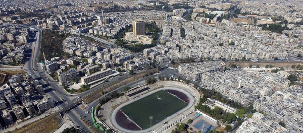 Le stade d'Alep contrôlé par l'armée gouvernementale où des bus attendent les habitants souhaitant quitter la ville - Sputnik Afrique