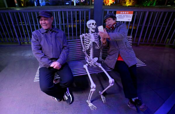 Китайская женщина снимает селфи со скелетом в Пекине - Sputnik Afrique