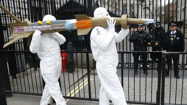 Les membres d'Amnesty International protestent en portant une maquette d'un missile contre la vente des armes par le gouvernement britannique d'armes à l'Arabie saoudite en dehors de Downing Street à Londres, vendredi le 18 mars 2016 - Sputnik Afrique