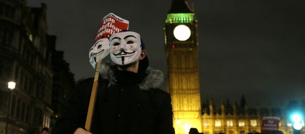 A masked demonstrator stands in Parliament Square during the Million Mask protest march in London on Thursday Nov. 5, 2015. A masked demonstrator stands in Parliament Square during the Million Mask protest march in London on Thursday Nov. 5, 2015. - Sputnik Afrique