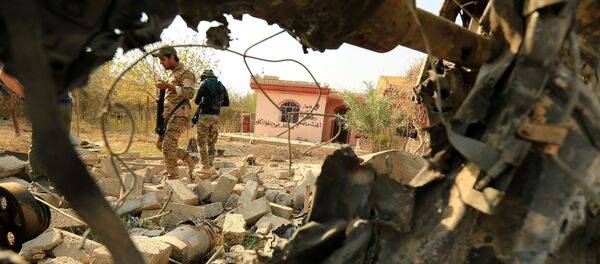 Iraqi security forces walk amidst rubble near a wreckage of a vehicle that was destroyed during clashes in Hammam al-Alil, south of Mosul, during an operation to attack Islamic State militants in Mosul, Iraq November 7, 2016. Iraqi security forces walk amidst rubble near a wreckage of a vehicle that was destroyed during clashes in Hammam al-Alil, south of Mosul, during an operation to attack Islamic State militants in Mosul, Iraq November 7, 2016. - Sputnik Afrique