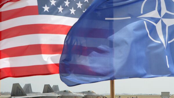 The US and The NATO flag flie in front of two US Air Force F-22 Raptor fighter aircrafts at the Air Base of the Lithuanian Armed Forces in Šiauliai, Lithuania, on April 27, 2016. - Sputnik Afrique