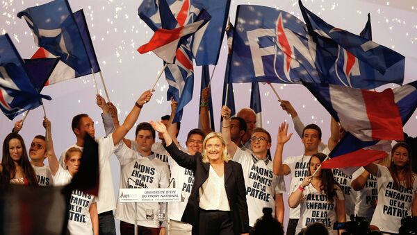 France’s far-right National Front president Marine Le Pen, center, surrounded by members, waves to supporters after her speech during their meeting in Marseille, southern France, Saturday, Sep. 6, 2015. - Sputnik Afrique