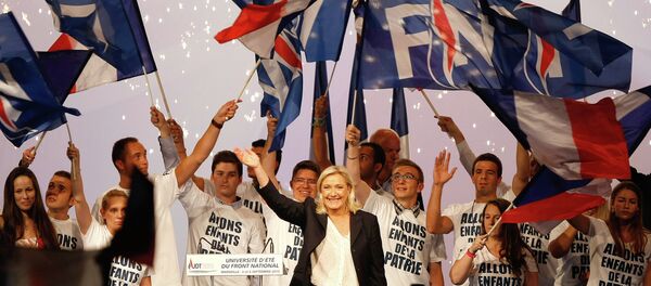 France’s far-right National Front president Marine Le Pen, center, surrounded by members, waves to supporters after her speech during their meeting in Marseille, southern France, Saturday, Sep. 6, 2015. - Sputnik Afrique