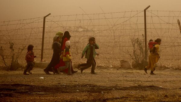 Дети идут вдоль забора во время песчаной бури в лагере беженцев недалеко от деревни Айн Исса, Сирия - Sputnik Afrique