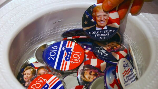 A guest at an event called the U.S. Presidential Election Watch, organised by the U.S. Consulate, reaches for a badge from out of a hat displaying photographs of Republican candidate Donald Trump and Democratic candidate Hillary Clinton, in Sydney, Australia - Sputnik Afrique