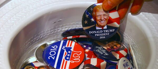 A guest at an event called the U.S. Presidential Election Watch, organised by the U.S. Consulate, reaches for a badge from out of a hat displaying photographs of Republican candidate Donald Trump and Democratic candidate Hillary Clinton, in Sydney, Australia - Sputnik Afrique