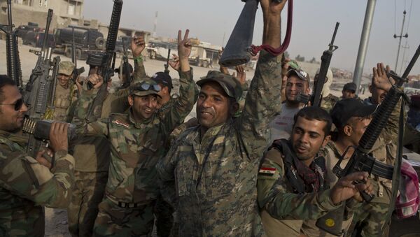 Iraqi army soldiers raise their weapons in celebration on the outskirts of Qayara, Iraq, Wednesday, Oct. 19, 2016. - Sputnik Afrique