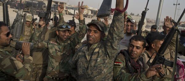 Iraqi army soldiers raise their weapons in celebration on the outskirts of Qayara, Iraq, Wednesday, Oct. 19, 2016. Iraqi army soldiers raise their weapons in celebration on the outskirts of Qayara, Iraq, Wednesday, Oct. 19, 2016. - Sputnik Afrique