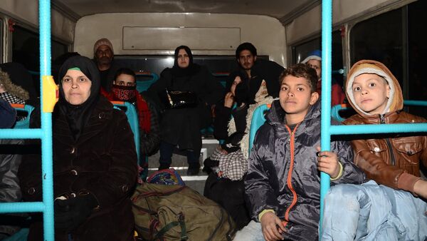 Syrian families, from various eastern districts of Aleppo, are evacuated by bus through Sheikh Maqsud, a Kurdish-controlled enclave between the government-held west of Aleppo and the east, on November 27, 2016 - Sputnik Afrique