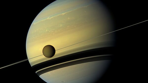Saturn's largest moon Titan passing in front of the giant planet in an image made by NASA's Cassini spacecraft - Sputnik Afrique