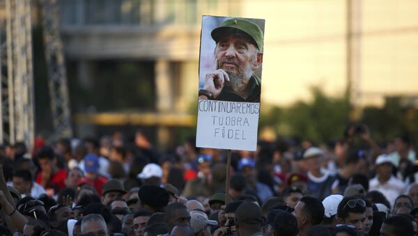 A mourner carries a picture of Cuba's late President Fidel Castro before paying tribute to Castro at Revolution Square in Havana, Cuba - Sputnik Afrique