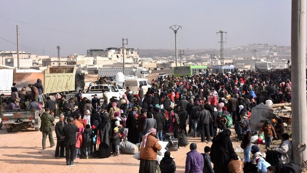 Syrians that evacuated the eastern districts of Aleppo gather to board buses, in a government held area in Aleppo, Syria in this handout picture provided by SANA on November 29, 2016. - Sputnik Afrique