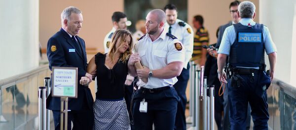 Security guards hold a protester as they remove a group from the House of Representatives after they began chanting slogans regarding the offshore detention of asylum seekers during Question Time in Parliament House, Canberra, Australia, November 30, 2016. - Sputnik Afrique