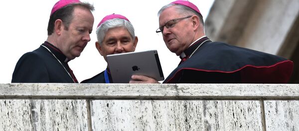Bishops looks at the screen of a tablet as they await the arrival of the Pope for the Synod on the family at the Vatican on October 15, 2015. - Sputnik Afrique