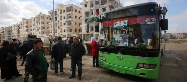 Syrians, from various western districts, wait at the Razi bus stop in Aleppo's central Jamiliyeh neighbourhood before taking part in a bus trip through government-held territory between the two sides of the divided city on December 3, 2016 as the pro-government forces seized 60 percent of the former rebel stronghold in east Aleppo - Sputnik Afrique