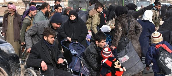 Syrians that evacuated the eastern districts of Aleppo rest, while waiting to board buses, in a government held area in Aleppo, Syria in this handout picture provided by SANA on November 29, 2016 - Sputnik Afrique