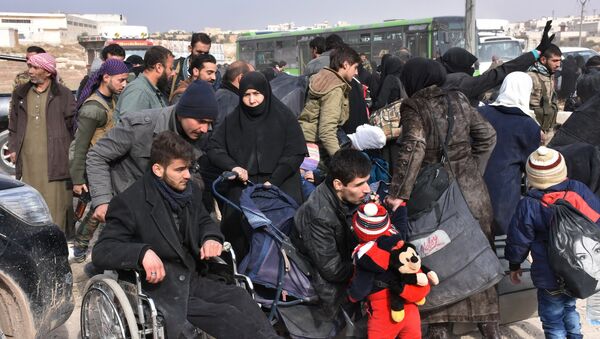 Syrians that evacuated the eastern districts of Aleppo rest, while waiting to board buses, in a government held area in Aleppo, Syria in this handout picture provided by SANA on November 29, 2016 - Sputnik Afrique