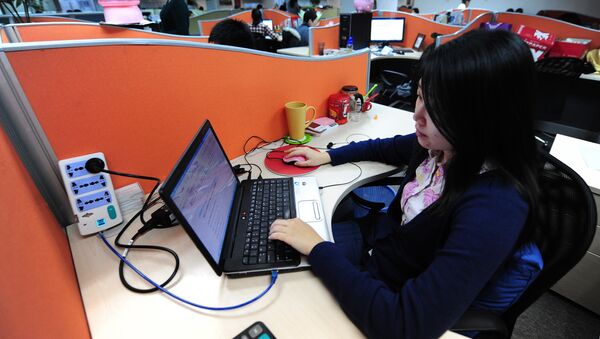 A woman works online in her cubicle at an office in Beijing on February 4, 2010. - Sputnik Afrique