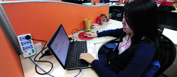 A woman works online in her cubicle at an office in Beijing on February 4, 2010. - Sputnik Afrique