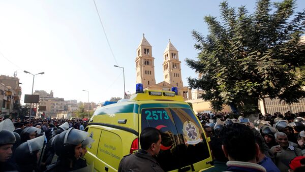 An ambulance passes through riot police as Christians shout slogans in front of Cairo’s Coptic Cathedral after an explosion inside the cathedral in Cairo - Sputnik Afrique