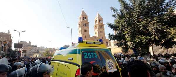 An ambulance passes through riot police as Christians shout slogans in front of Cairo’s Coptic Cathedral after an explosion inside the cathedral in Cairo - Sputnik Afrique