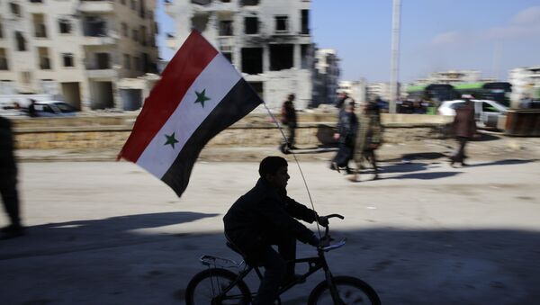 A Syrian boy rides a bike adorned with a Syrian flag as Syrians families, who were displaced from east Aleppo last month, return to their homes in the Hanano district of eastern Aleppo, Syria, Sunday, Dec. 4, 2016. - Sputnik Afrique