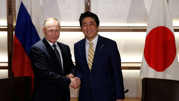 Russia's President Vladimir Putin (L) shakes hands with Japan's Prime Minister Shinzo Abe at the start of their summit meeting in Nagato, Yamaguchi prefecture, Japan, December 15, 2016. - Sputnik Afrique
