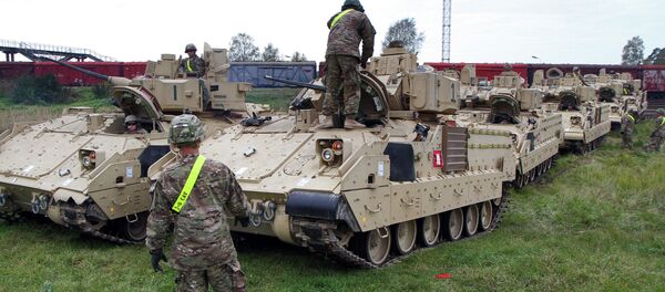Members of the US Army 1st Brigade, 1st Cavalry Division, unload Bradley Fighting Vehicles at the railway station near the Rukla military base in Lithuania, on October 4, 2014 Members of the US Army 1st Brigade, 1st Cavalry Division, unload Bradley Fighting Vehicles at the railway station near the Rukla military base in Lithuania, on October 4, 2014 - Sputnik Afrique