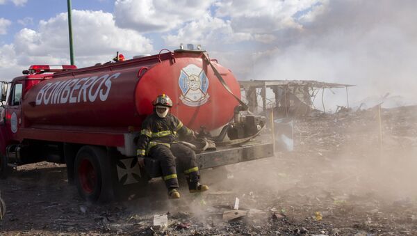 A firefighter takes a rest amid the smouldering ruins left by a blast in a fireworks market that killed at least 26 and injured dozens, in Mexico City, on December 20, 2016. - Sputnik Afrique