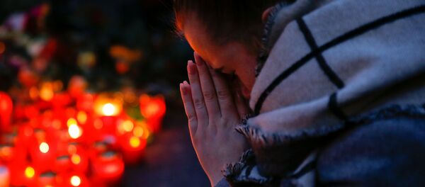A woman prays next to lit candles at the Christmas market in Berlin, Germany, December 20, 2016 - Sputnik Afrique