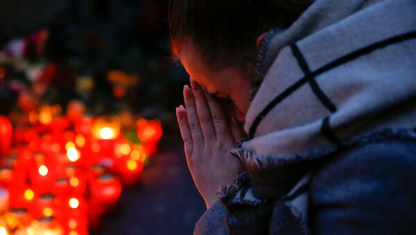 A woman prays next to lit candles at the Christmas market in Berlin, Germany, December 20, 2016 - Sputnik Afrique