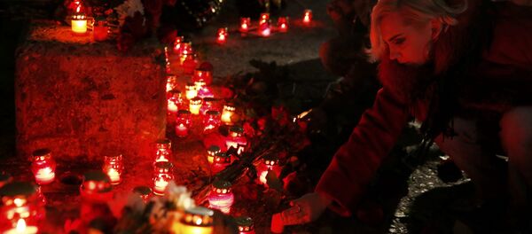 People place candles to honour passengers and crew members of Russian military Tu-154 plane crashed into the Black Sea on its way to Syria on Sunday in the resort city of Sochi, Russia - Sputnik Afrique