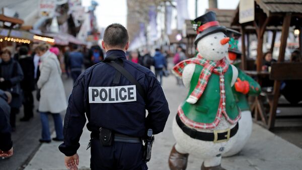 A French police officer patrols a Christmas market as emergency security measures continue on the Champs Elysees Avenue in Paris, France, December 20, 2016. - Sputnik Afrique