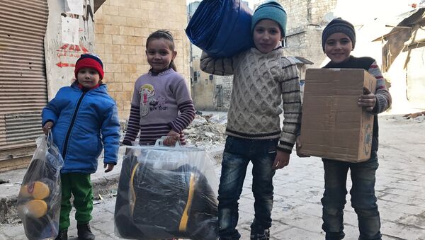 Дети, получившие первую гуманитарную помощь, в восточном квартале Алеппо. - Sputnik Afrique