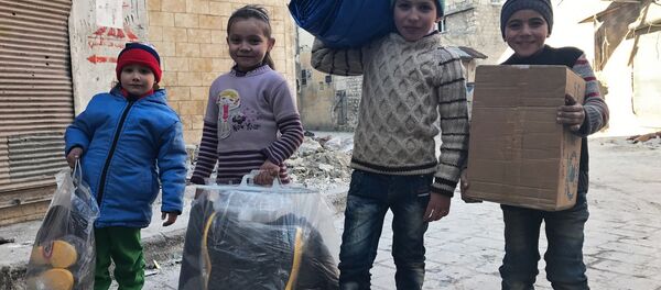 Дети, получившие первую гуманитарную помощь, в восточном квартале Алеппо. - Sputnik Afrique
