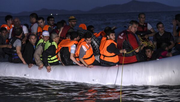 Migrants board an inflatable boat to reach the Greek island of Kos, early on August 19, 2015, near the shore of Bodrum, southwest Turkey. - Sputnik Afrique