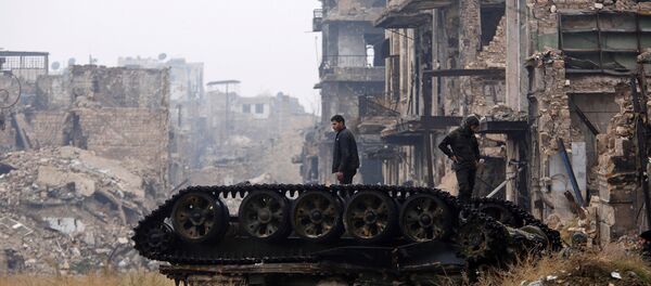 Forces loyal to Syria's President Bashar al-Assad stand atop a damaged tank near Umayyad mosque, in the government-controlled area of Aleppo, during a media tour, Syria - Sputnik Afrique