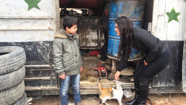 Carla Ortiz avec un enfant en Syrie - Sputnik Afrique