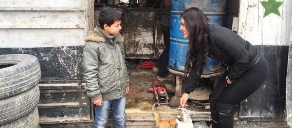 Carla Ortiz avec un enfant en Syrie - Sputnik Afrique