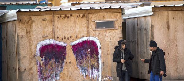 Migrants walk in a refugee camp on December 14, 2016 in Grande-Synthe, northern France. - Sputnik Afrique