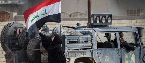 An Iraqi woman fleeing the fighting touches her country's national flag mounted on a security forces vehicle as she reaches an area held by Iraqi Special Forces 2nd division in the Samah neighbourhood of Mosul on November 15, 2016. - Sputnik Afrique
