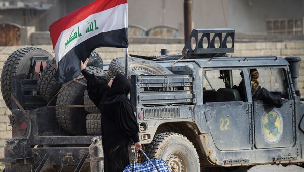 An Iraqi woman fleeing the fighting touches her country's national flag mounted on a security forces vehicle as she reaches an area held by Iraqi Special Forces 2nd division in the Samah neighbourhood of Mosul on November 15, 2016. - Sputnik Afrique