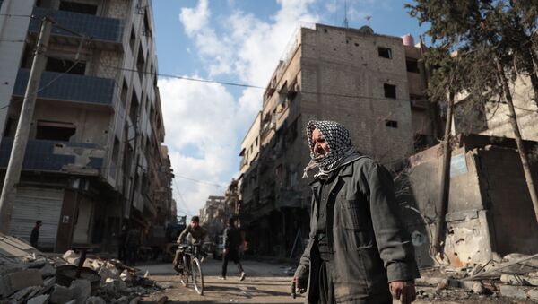 Le Syrien Abou Khaled regarde les décombres de sa maison détruite dans la ville de Douma, dans la banlieue est de Damas, le 30 décembre 2016, le premier jour de la trêve nationale - Sputnik Afrique