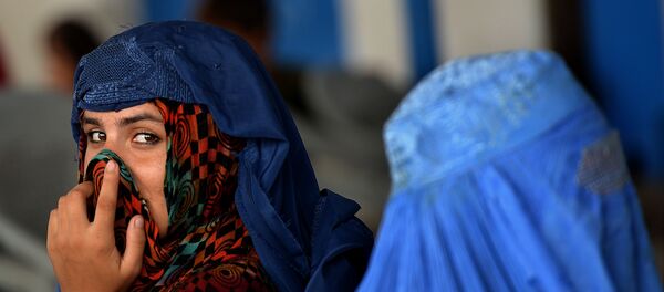 Afghan refugee women wait to board trucks at the United Nations High Commissioner for Refugees (UNHCR) repatriation centre on the outskirts of Peshawar on July 28, 2016, - Sputnik Afrique