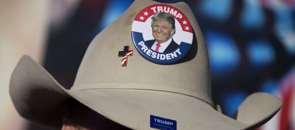 Trump supporter Kraig Moss sings in front of a large painting by artist Julian Raven during a Truckers for Trump convoy event for Republican Presidential Candidate Donald Trump in Des Moines, Iowa, January 28, 2016, ahead of the Iowa Caucus. With five days to go before the first vote in the US presidential nominations process in Iowa, Republican frontrunner Donald Trump is dominating the airwaves. Trump supporter Kraig Moss sings in front of a large painting by artist Julian Raven during a Truckers for Trump convoy event for Republican Presidential Candidate Donald Trump in Des Moines, Iowa, January 28, 2016, ahead of the Iowa Caucus. With five days to go before the first vote in the US presidential nominations process in Iowa, Republican frontrunner Donald Trump is dominating the airwaves. - Sputnik Afrique