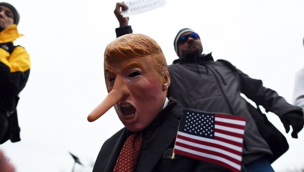 Demonstrators protest against US President-elect Donald Trump before his inauguration on January 20, 2017, in Washington, DC. - Sputnik Afrique