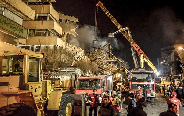 Les pompiers déblaient les décombres sur les lieux de l'effondrement d'un immeuble à Téhéran - Sputnik Afrique