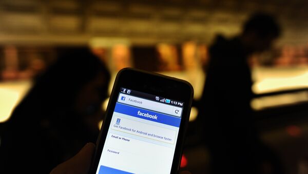 A man checks facebook on his smartphone while waiting for a train in a metro station in Washington, DC, on May 9, 2012.  - Sputnik Afrique